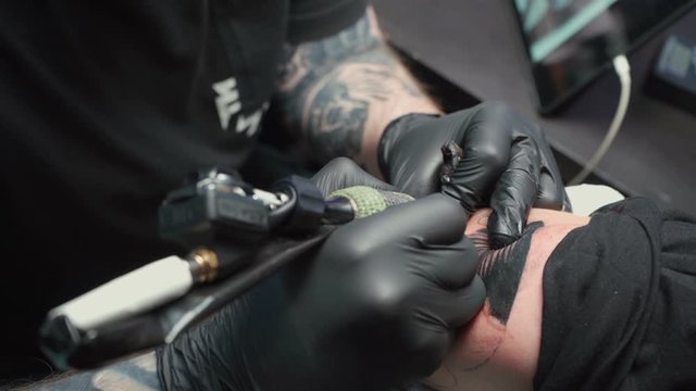 Shooting of professional getting tattoo of snake in salon