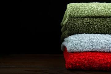 stack of folded clean towels on dark background with copy space