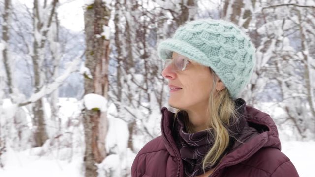 Close Up Of Blonde Woman With Glasses Walking In Snowy Landscape