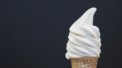 Soft serve ice cream cone on black background. (close up )