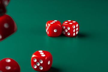 Red dice on green background close up