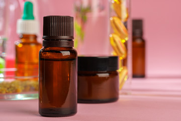 Health, skin care and beauty concept. Cosmetic containers on pink background with plant leaves