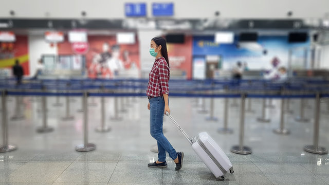 Asian Tourist With Luggage ,wearing Mask To Prevent During Travel Time At The Airport Terminal For Protect From The New Coronavirus 2019 Infection Outbreak Situation