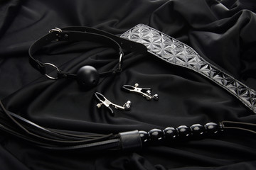 various sex toys on black textile background