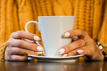 hand holding cup of coffee on table