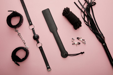 top view of black sex toys on pink background