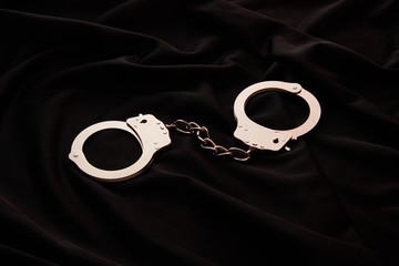 metal handcuffs on black textile background