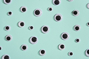 pattern of googly eyes on blue mint background