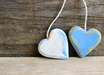 Two wooden hearts with texture isolated on old wooden background. Love, wedding, Valentine's Day concept