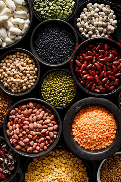 Legumes, a set consisting of different types of beans, lentils and peas on a black background, top view, close up. The concept of healthy and nutritious food