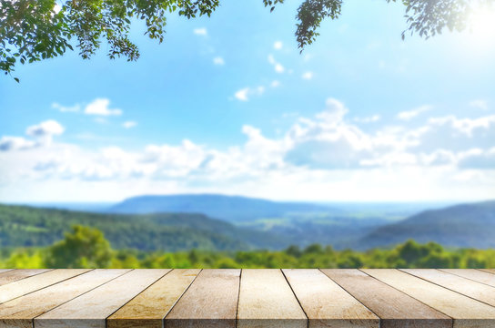 Wooden table against mountain, hill, blurry background.