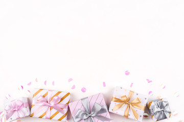Set of gift boxes with bows and confetti on a white background. Flat lay composition. Birthday, christmas, wedding or another holiday concept.