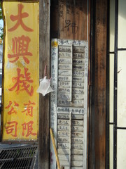 Red and yellow Chinese sign, wall filled with Chinese characters
