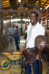 Farm workers preparing horse harness