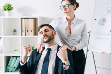 sexy secretary with big breast doing massage to businessman in office