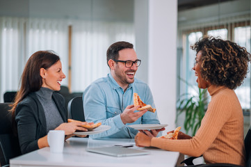 Obraz premium Friends laughing and eating pizza.