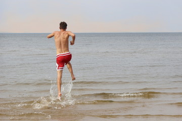Fototapeta na wymiar Ragazzo salta nel mare