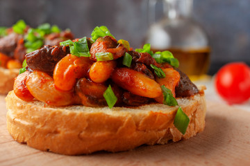 Bruschetta with beans and mushrooms on a wooden board