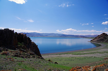 Western mongolian lake amonge the mountains and blue sky with clouds