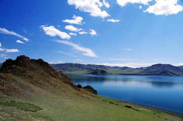Naklejka na ściany i meble Western mongolian lake amonge the mountains and blue sky with clouds