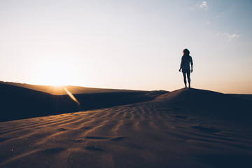 Fototapeta na wymiar Woman enjoying sunset in desert