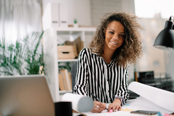 African architect working on new project. Businesswoman in office. 