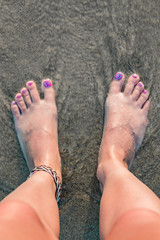 Woman's feet on a sandy beach, time for summertime !