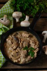 Slow cooked pork stew with mushrooms in creamy sauce