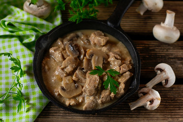 Slow cooked pork stew with mushrooms in creamy sauce
