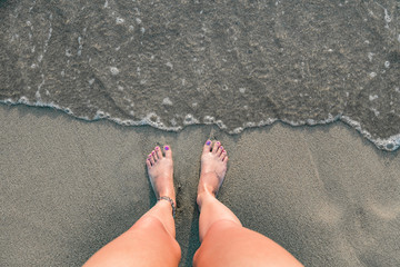 Woman's feet on a sandy beach, time for summertime !