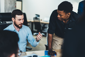 Confident male explaining project to partners in office