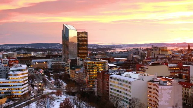 Oslo, Norway. A night view of Sentrum area of Oslo, Norway, with modern and historical buildings and car traffic. Sunset colorful sky in winter with snow