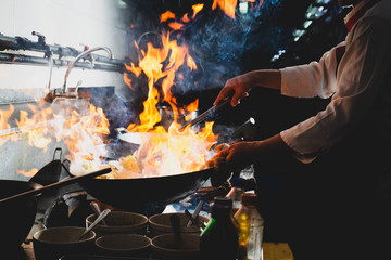 Chef stir fry cooking in kitchen