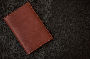 brown leather wallet on black background. Top view, copy space.
