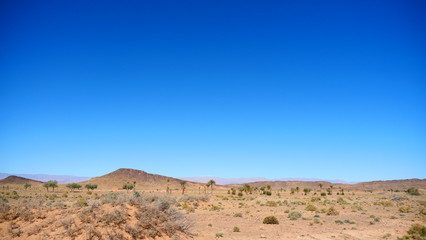 Bright landscape of Morocco, breathtaking curves of mountains, stunning combination of hills & farm land,inadvertent distribution of houses & huts, raw impression of pure nature.