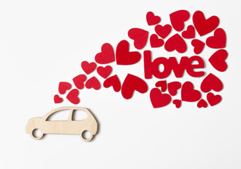 miniature toy car delivering red hearts for Valentine's day on white background