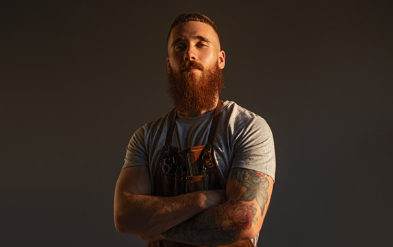 Confident male hairdresser with crossed arms