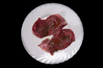  Beef heart slices in a white plate, on a black background