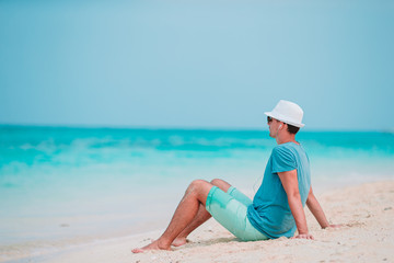 Fototapeta na wymiar Young man on the white tropical beach