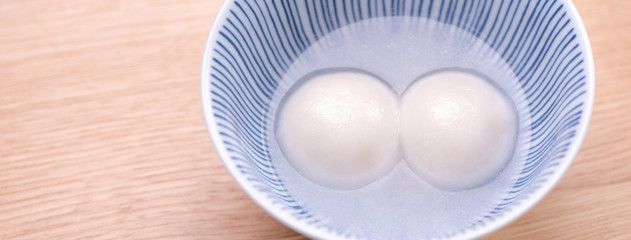 Tang yuan, tangyuan, yuanxiao in a small bowl. Delicious asian traditional festive food rice dumpling balls with stuffed fillings for Chinese Lantern Festival, close up.