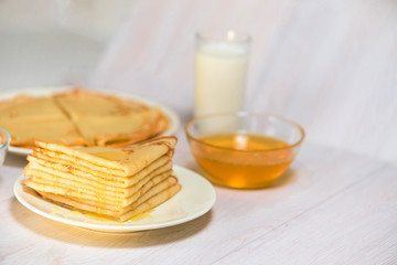 Fototapeta na wymiar Maslenitsa is a national holiday at the end of February . pancakes are fried for a week with honey on a light background. blini . space for text