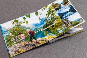 Photobook album on deck table with travel photos