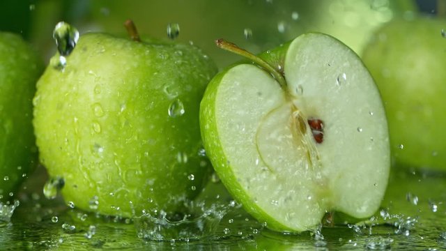 Super Slow Motion Shot of Water Splashing on Fresh Cutted Green Apple at 1000fps.