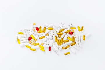 Multi-colored pills and tablets on a white background. Health concept. Top view with copy space.