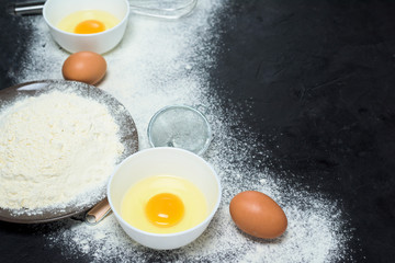 Maslenitsa is a traditional holiday in February . Ingredients for baking pancakes. frying pan, eggs, flour, egg beater, on a dark wooden background top view. top view, place to copy text, recipe.