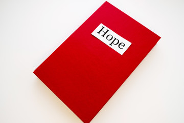 on the cover of the red book is written hope sheet of white paper