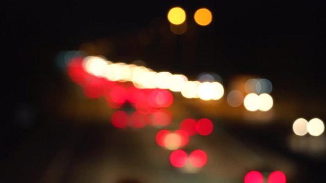 City lights out of focus, abstract background of bright red and white lights of car's headlights
