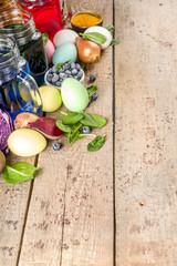 Easter organic and zero waste concept. Easter eggs painted with natural egg dye, fruits and vegetables. Wooden background