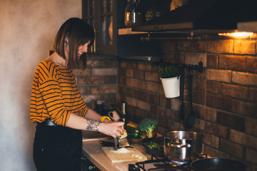 Beautiful woman cooking pasta on modern kitchen.