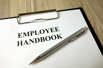 Employee handbook with pen on desk